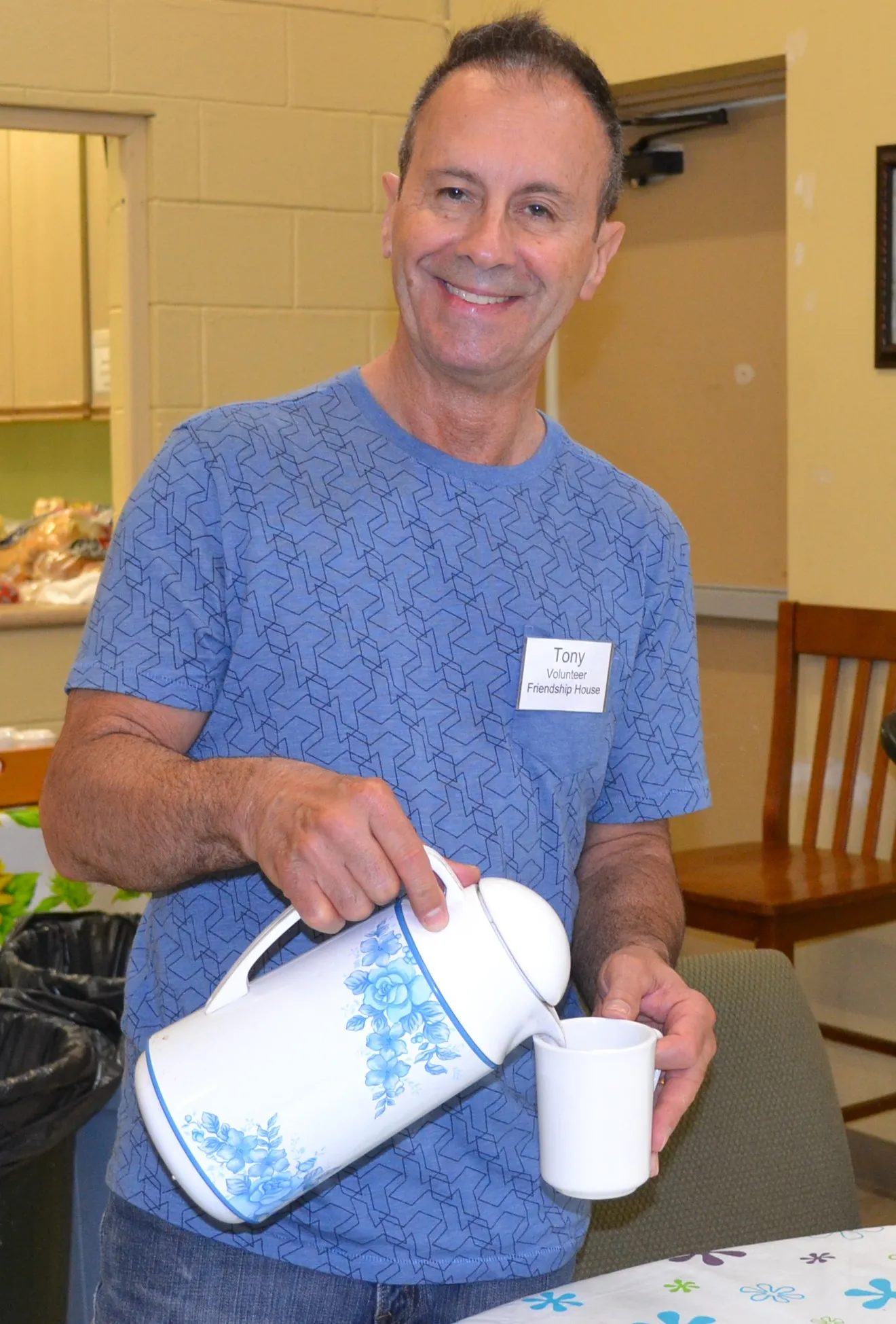 A volunteer pouring coffee